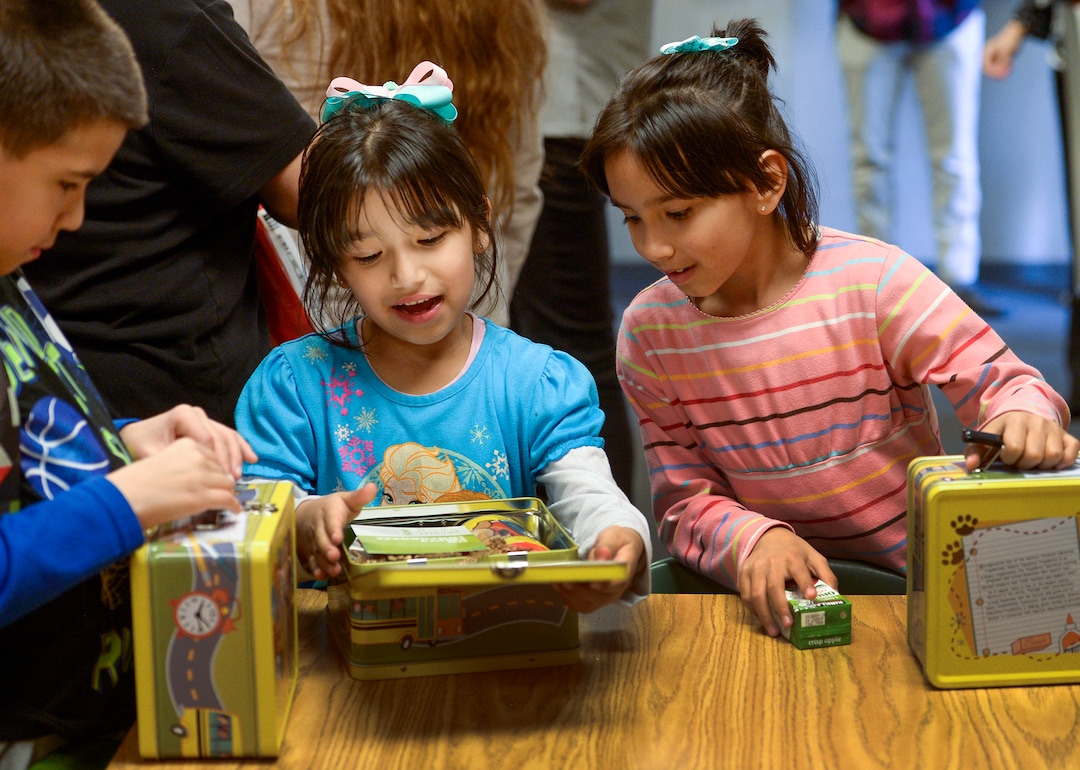 (Leah Hogsten  |  The Salt Lake Tribune) l-r Siblings Jonathan Escobar, Elizabeth Escobar and Diana Escobar like their new lunch boxes and what's inside them, Tuesday, March 13, 2018 during a food pantry dedication at their school. Smiths Food & Drug is helping to open a food pantry at David Gourley Elementary School in Kearns, where 80 percent of the 646 students qualify for free or reduced lunches. 
