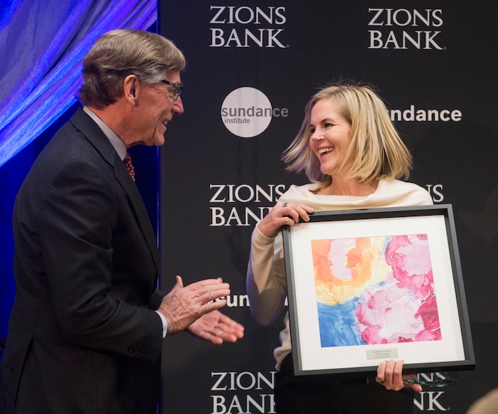 (Rick Egan  |  The Salt Lake Tribune)     Stephenie Larsen, founder of Encircle House, receives a leadership award from Scott Anderson, president and CEO of Zions Bank, at the 2018 Sundance Film Festival Utah Women’s Leadership Celebration in Park City on Thursday, Jan. 25, 2018.