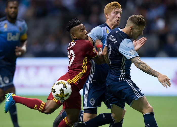 Real Salt Lake's Joao Plata, left, collides with Vancouver Whitecaps' Tim Parker, center, and Jordan Harvey during the first half of an MLS soccer match Saturday, Sept. 9, 2017, in Vancouver, British Columbia. (Darryl Dyck/The Canadian Press via AP)