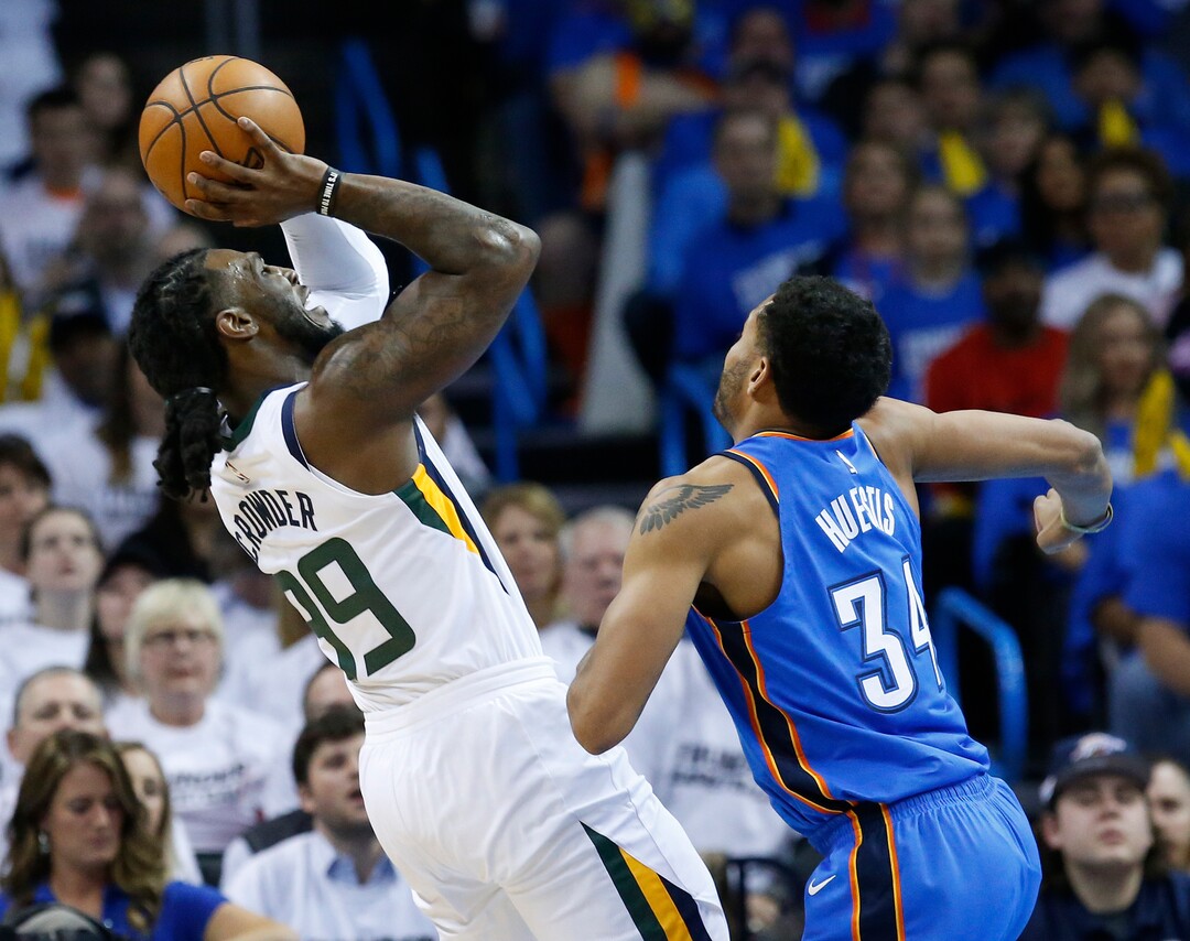 Utah Jazz forward Jae Crowder, left, shoots in front of Oklahoma City Thunder guard Josh Huestis (34) during the first half of Game 5 of an NBA basketball first-round playoff series in Oklahoma City, Wednesday, April 25, 2018. (AP Photo/Sue Ogrocki)