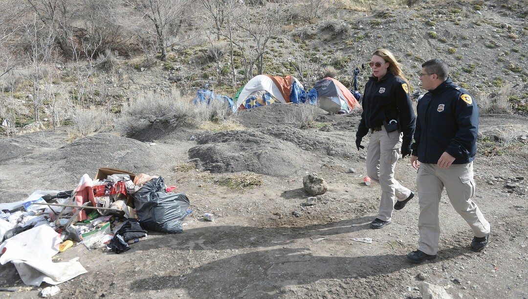 (Al Hartmann  |  The Salt Lake Tribune) 	Salt Lake City police officers Lt. Robin Heiden and Cpt. Tyrone Farillas walk the hills above Victory Road to tell homeless camped in the hills to visit the mobile homeless outreach center Thursday Feb. 15 2018.  Salt Lake City Police, Volunteers of America, Utah Highway Patrol, and social workers from Salt Lake City and the Veterans Administration set up an outreach center along Victory Road below the state capitol to help provide services to homeless camped in the hills near a gravel quarry.  These 40 or 50 homeless would rather camp outside than take advantage of shelters.  