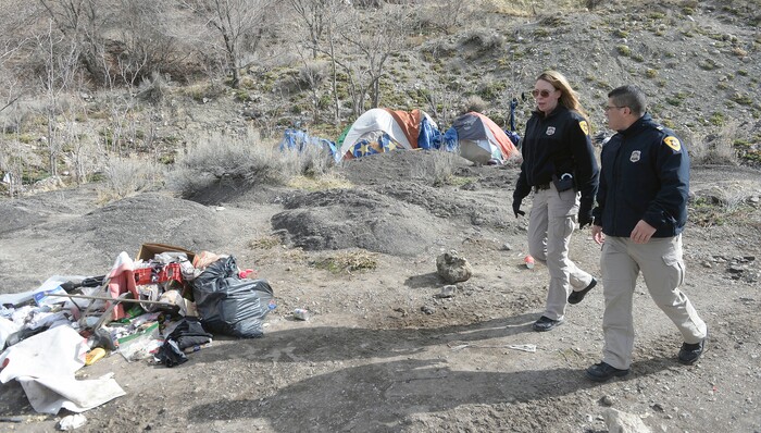 (Al Hartmann  |  The Salt Lake Tribune) 	
Salt Lake City police officers Lt. Robin Heiden and Cpt. Tyrone Farillas walk the hills above Victory Road to tell homeless camped in the hills to visit the mobile homeless outreach center Thursday Feb. 15 2018.  Salt Lake City Police, Volunteers of America, Utah Highway Patrol, and social workers from Salt Lake City and the Veterans Administration set up an outreach center along Victory Road below the state capitol to help provide services to homeless camped in the hills near a gravel quarry.  These 40 or 50 homeless would rather camp outside than take advantage of shelters.  