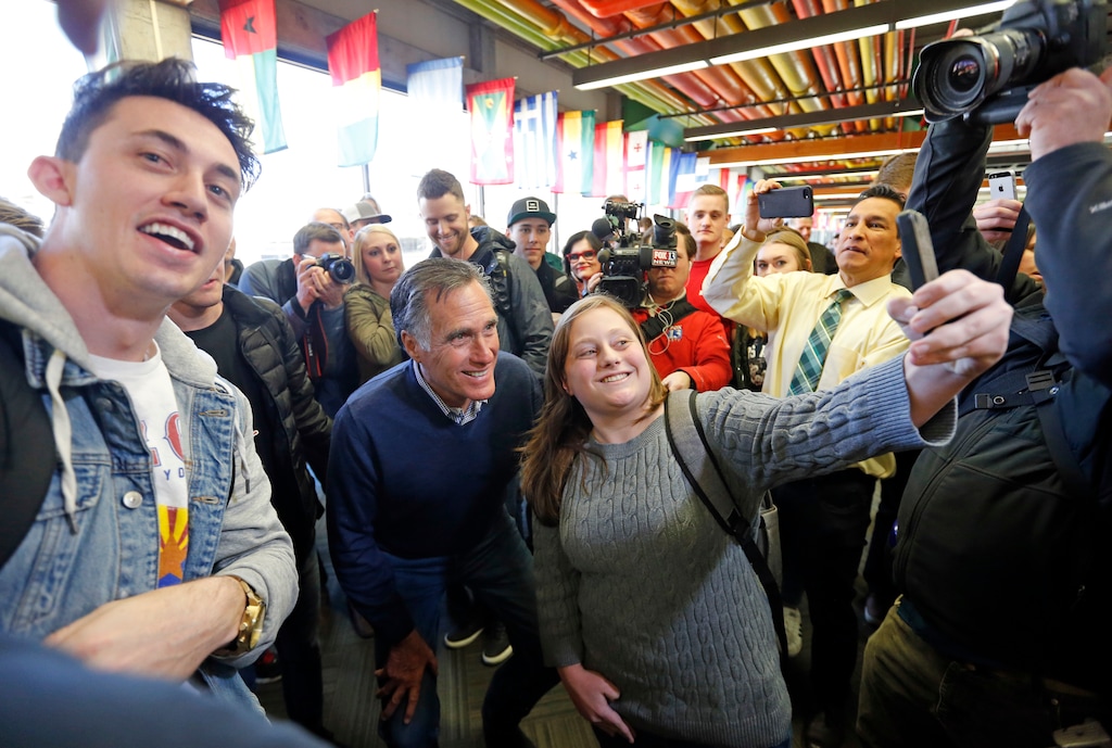 FILE - In this Feb. 16, 2018, file photo, former Republican presidential candidate Mitt Romney poses for a photograph as he greets students at Utah Valley University in Orem, Utah. Romney is running for re-election to Marriott International's board of directors, but his campaign said Monday that he'll resign from that post if elected in November to the U.S. Senate, which bars senators from serving as an officer or board member of any publicly-held company. (AP Photo/Rick Bowmer, File)