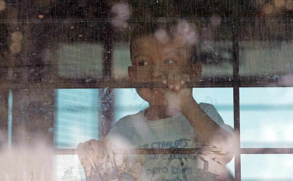 (David J. Phillip | AP file photo)  An immigrant child looks out from a U.S. Border Patrol bus leaving as protesters block the street outside the U.S. Border Patrol Central Processing Center in McAllen, Texas, on June 23, 2018. Immigrant children described hunger, cold and fear in a voluminous court filing about the facilities where they were held in the days after crossing the border. Advocates fanned out across the southwest to interview more than 200 immigrant parents and children about conditions in U.S. holding facilities, detention centers and a youth shelter. The accounts form part of a case over whether the government is complying with a longstanding settlement over the treatment of immigrant youth in custody.