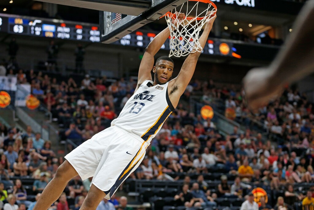 Utah Jazz Tony Bradley (13) hangs after dunking against the Memphis Grizzlies during the second half of an NBA summer league game Monday, July 1, 2019, in Salt Lake City. (AP Photo/Rick Bowmer)