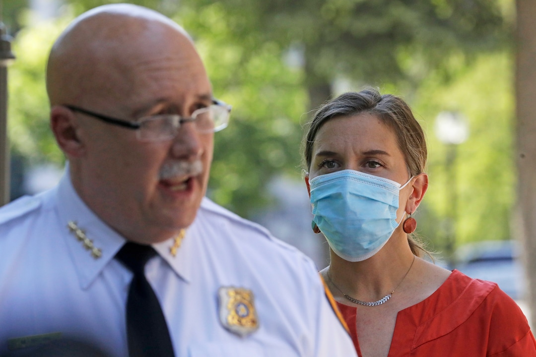Salt Lake City Mayor Erin Mendenhal listens as Salt Lake City police Chief Mike Brown speaks during a news conference Monday, Aug. 3, 2020, in Salt Lake City. Mendenhall signed an executive order Monday directing the police chief to enact several new policies, such as mandating deescalation tactics before using force, by Sept. 5. Previously, officers only needed to use "objectively reasonable" force, but under this order they must only use force when necessary and if it is proportionate to the situation. (AP Photo/Rick Bowmer)