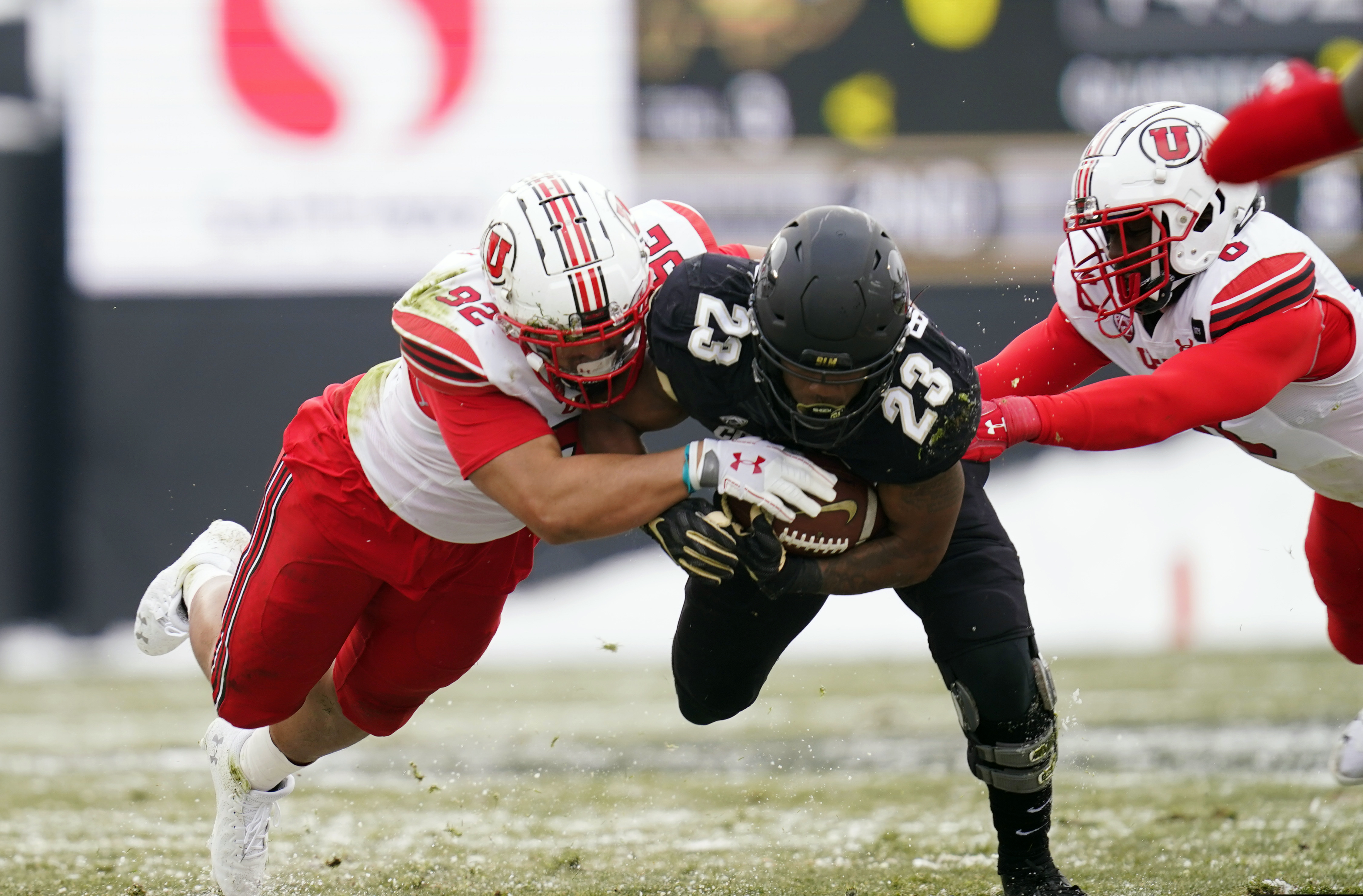 Colorado running back Jarek Broussard, center, is stopped after a short gain by Utah defensive end Maxs Tupai, left, and linebacker Devin Lloyd in the first half of an NCAA college football game Saturday, Dec. 12, 2020, in Boulder, Colo. (AP Photo/David Zalubowski)