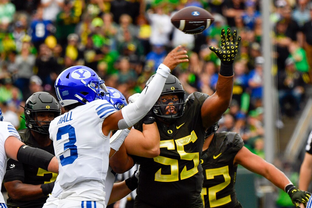 Oregon defensive lineman Taki Taimani (55) puts pressure on BYU quarterback Jaren Hall (3) during the first half of an NCAA college football game, Saturday, Sept. 17, 2022, in Eugene, Ore. (AP Photo/Andy Nelson)