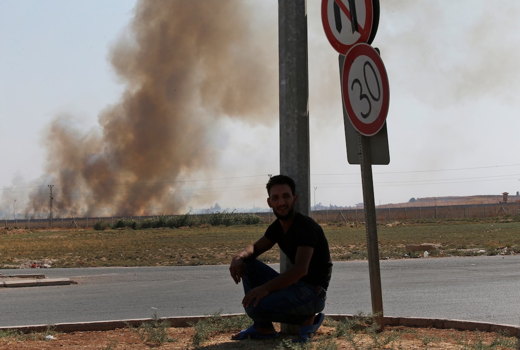 (Lefteris Pitarakis | AP) A man watches from Akcakale, Sanliurfa province, southeastern Turkey, as smoke billows from targets in Tel Abyad, Syria, during bombardment by Turkish forces, Sunday, Oct. 13, 2019. The United Nations says at least 130,000 people have been displaced by the fighting in northeastern Syria with many more likely on the move as a Turkish offensive in the area enters its fifth day.