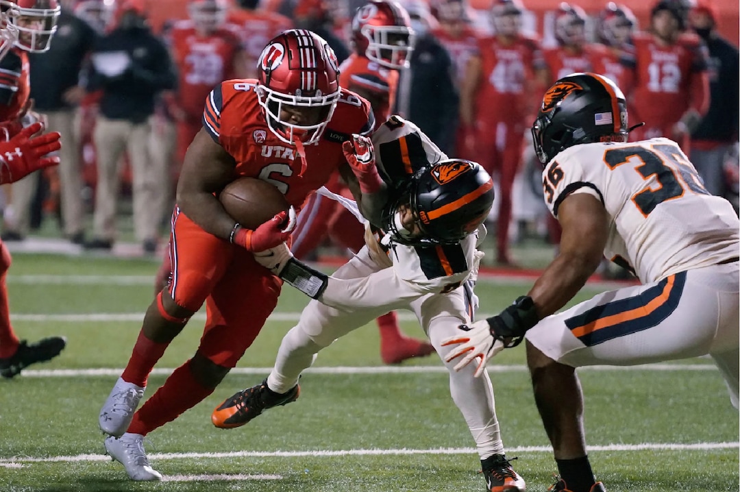 Utah running back Devin Brumfield (6) is tackled by Oregon State defensive back Akili Arnold (0) during the first half of an NCAA college football game Saturday, Dec. 5, 2020, in Salt Lake City. (AP Photo/Rick Bowmer)