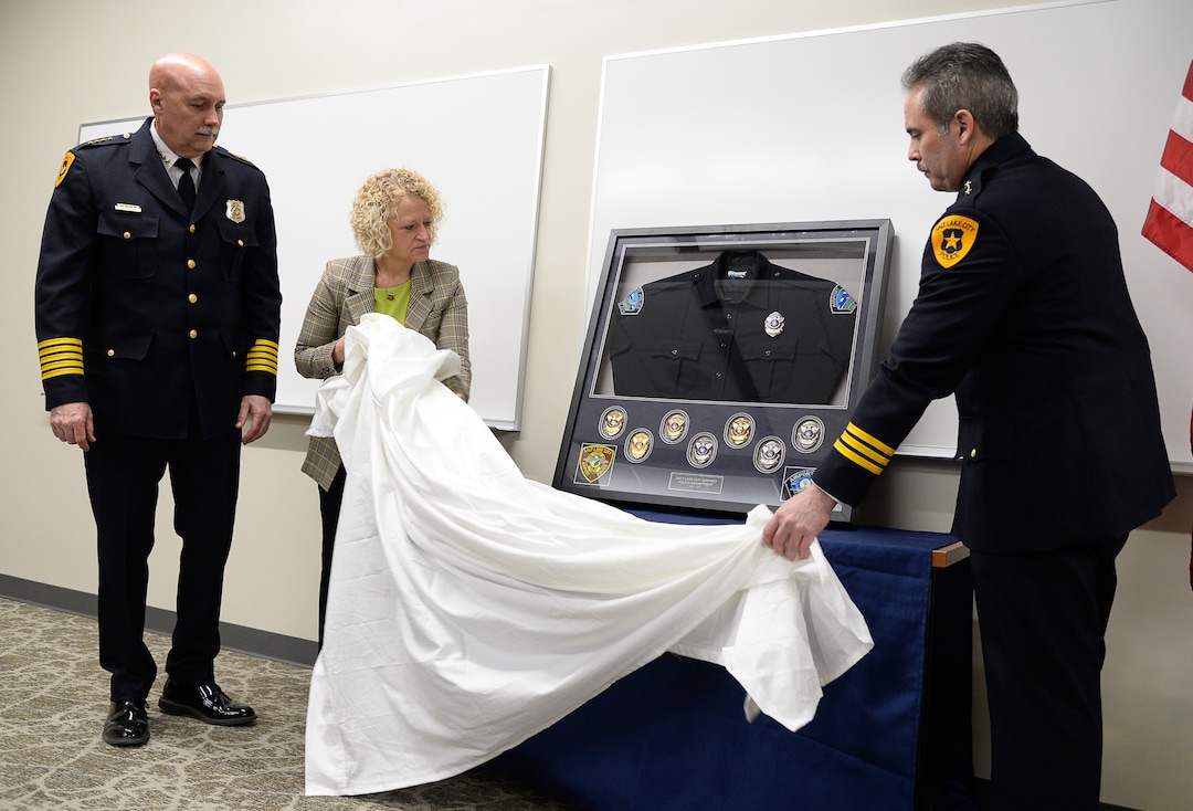 (Francisco Kjolseth  |  The Salt Lake Tribune)  Salt Lake City Police Chief Mike Brown, left, joins Salt Lake City Mayor Jackie Biskupski and Deputy Chief Craig Vargo as they reveal a shadow box of memorabilia holding former patches and badges held by the airport police following a ceremony to retire the airport police patch and badge on Tuesday, Feb. 26, 2019.  