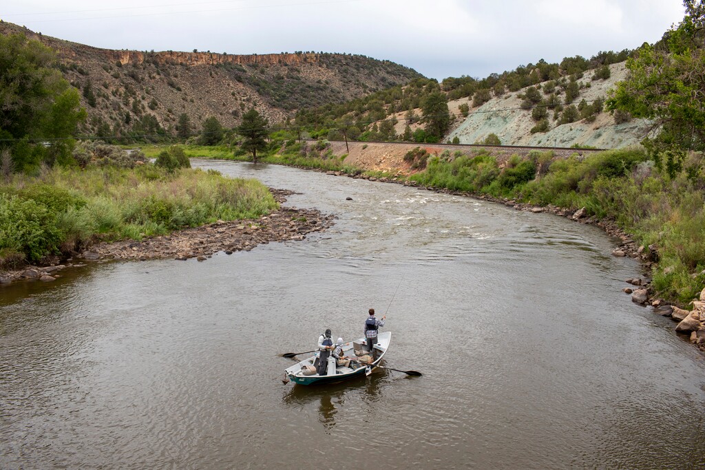 (Hugh Carey | The Colorado Sun via AP) Fisherman on a boat float on the Colorado River, June 27, 2021, near Burns, Colo. In November 1922, seven land-owning white men brokered a deal to allocate water from the Colorado River, which winds through the West and ends in Mexico. During the past two decades, pressure has intensified on the river as the driest 22-year stretch in the past 1,200 years has gripped the southwestern U.S.