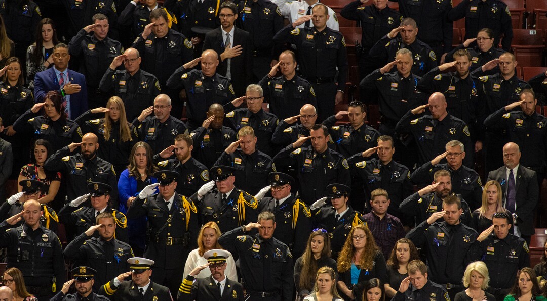 (Rick Egan  |  The Salt Lake Tribune)     Pall Police officers salute, during the funeral for South Salt Lake police officer, David Romrell, at the Maverik Center in West Valley City, Wednesday, Dec. 5, 2018.