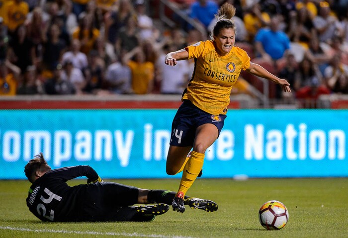 (Trent Nelson | The Salt Lake Tribune)  Utah Royals host Orlando Pride at Rio Tinto Stadium in Sandy, Wednesday May 9, 2018. Utah Royals FC forward Katie Stengel (24) leaps over Orlando Pride goalkeeper Ashlyn Harris (24).