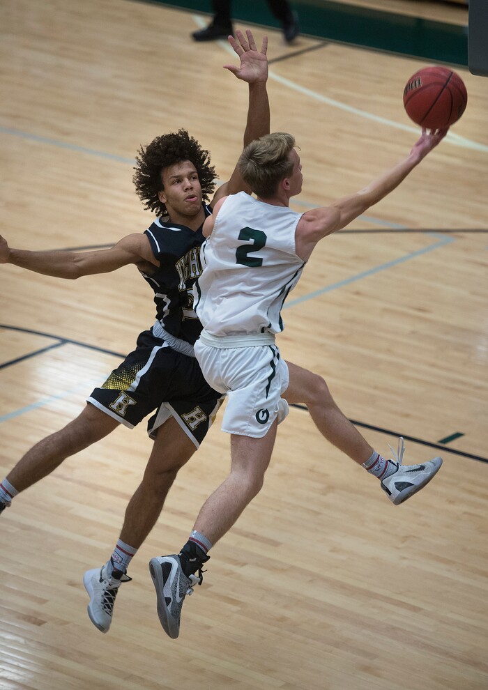 (Scott Sommerdorf   |  The Salt Lake Tribune)   Olympus' Jacob Dowdell drives to the basket alongside Highland's Trayton Keyes as the Titans defeated Highland 70-49, Friday, January 19, 2018.