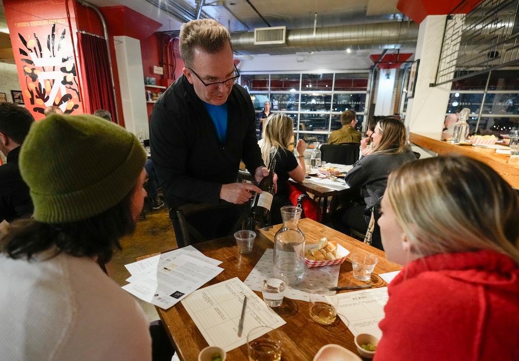 (Bethany Baker  |  The Salt Lake Tribune) Francis Fecteau, a wine instructor, shows customers various features on a wine label during a class on pairing wine with food at Caputo's Market & Deli in Salt Lake City on Wednesday, March 13, 2024.