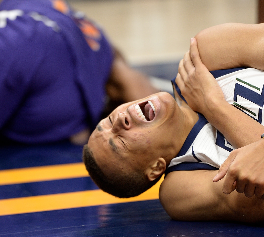 (Leah Hogsten  |  The Salt Lake Tribune) Utah Jazz guard Dante Exum (11) grimaces as he grabs his left shoulder after hitting the deck under the net as the Utah Jazz host the Phoenix Suns during preseason NBA basketball at Vivint Smart Home Arena in Salt Lake City, October 6, 2017.