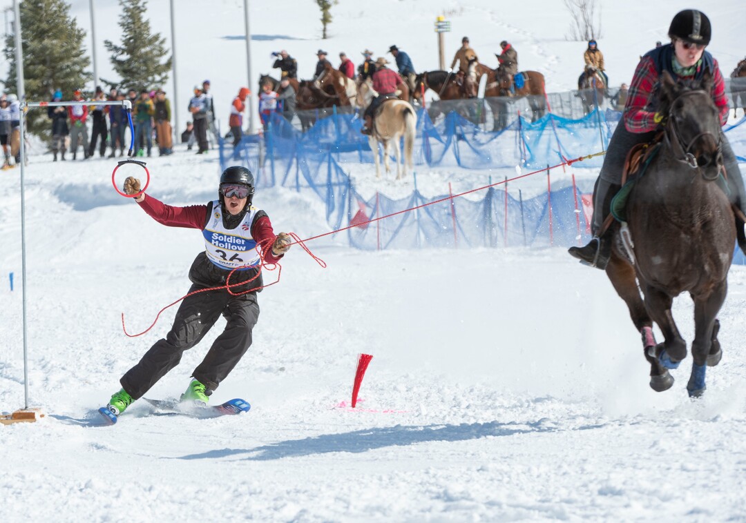(Rick Egan  |  The Salt Lake Tribune)   Sterling Graham grabs a ring, as he is pulled by Whitney Smith, riding River the horse, for the team "Ski Fast, Take Chances", in the first day of the Skijoring competition at Soldier Hollow Friday.  Feb. 22, 2019.  The competition continues on Saturday.