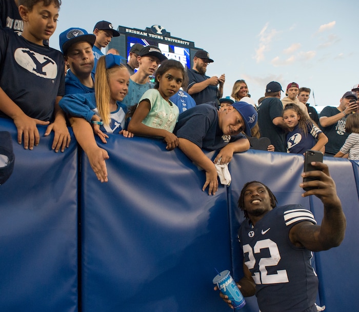 (Rick Egan  |  The Salt Lake Tribune)    Brigham Young Cougars running back Squally Canada (22) takes a selfie with a fan, after the Brigham Young Cougars defeated the McNeese State Cowboys 30-3, at Lavell Edwards Stadium, Saturday, Sept. 22, 2018.


