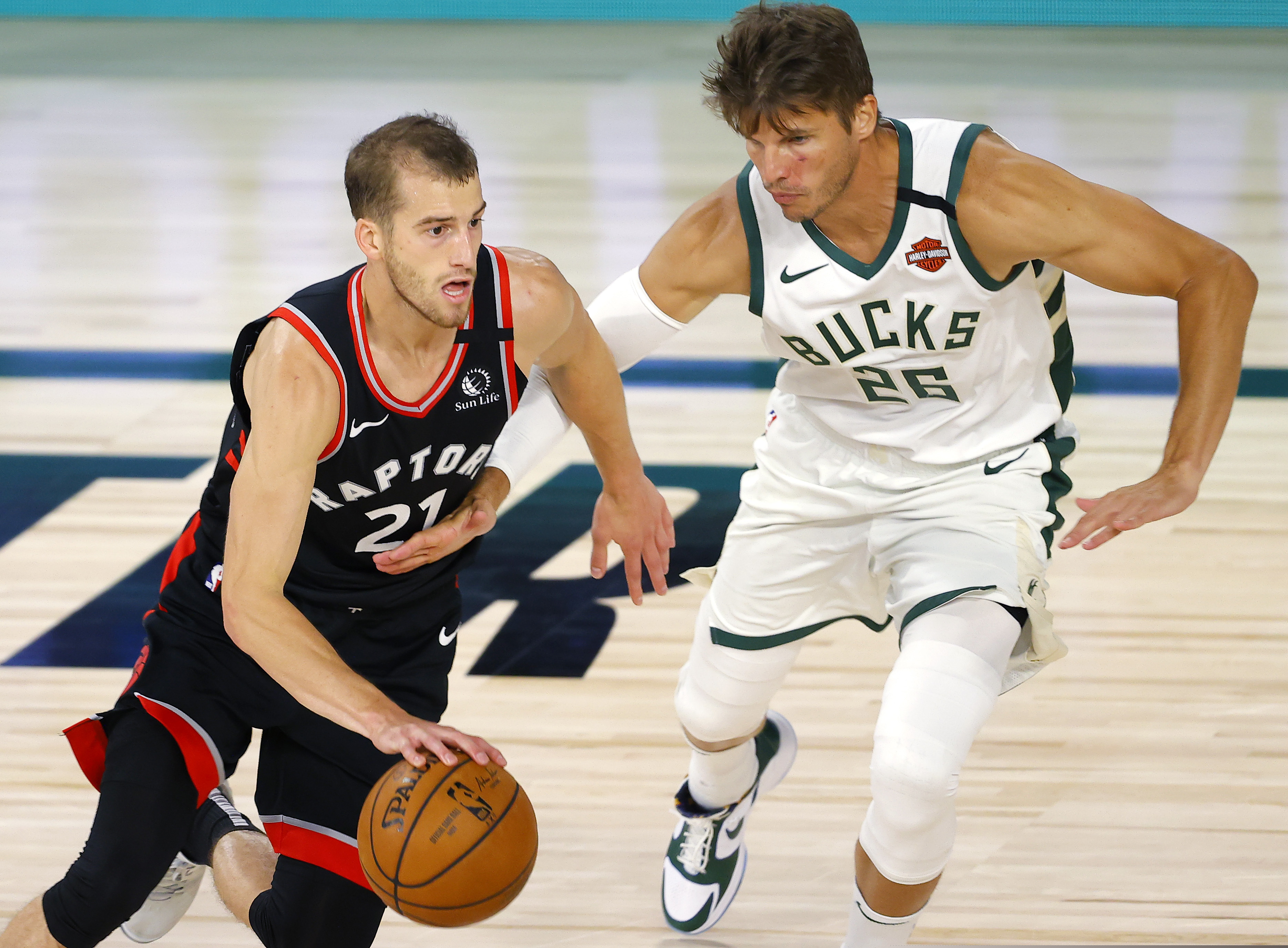 Milwaukee Bucks' Kyle Korver (26) pressures Toronto Raptors' Matt Thomas (21) during the fourth quarter of an NBA basketball game Monday, Aug. 10, 2020, in Lake Buena Vista, Fla. (Mike Ehrmann/Pool Photo via AP)