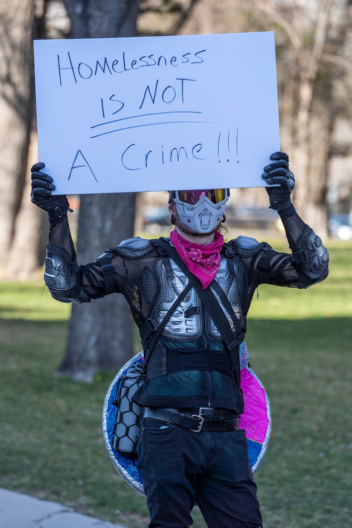 (Rick Egan | The Salt Lake Tribune) The Rainbow Resistor holds a sign, during a rally demanding an end to the policy of violence and terror inflicted on our unsheltered community at the hands of the Salt Lake County Health Department, Salt Lake City, and Salt Lake City Police Department, at Washington Square, on Friday, April 2, 2021.