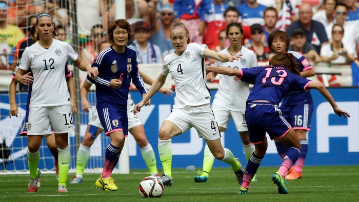 United States' Becky Sauerbrunn (4) drives the ball against Japan's Rumi Utsugi (13) during the second half of the FIFA Women's World Cup soccer championship in Vancouver, British Columbia, Canada, Sunday, July 5, 2015. (AP Photo/Elaine Thompson)