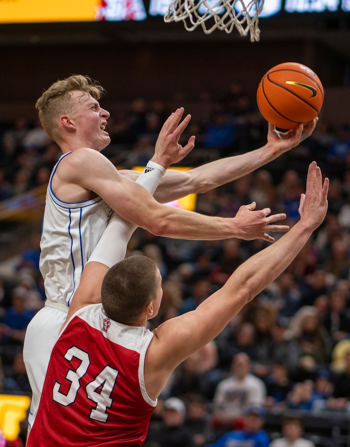 (Rick Egan | The Salt Lake Tribune)  Brigham Young Cougars guard Richie Saunders (15) takes the ball to the hoop, as South Dakota Coyotes forward Tasos Kamateros (34) defends, in basketball action between the Brigham Young Cougars and the South Dakota Coyotes, at Vivint Arena, in Salt Lake City, on Saturday, Dec. 3, 2022.

