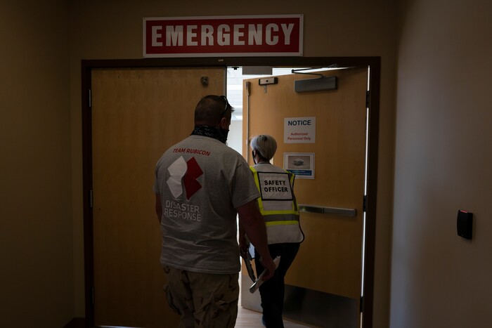 Scott Nargis, of Wisconsin, a U.S. Army veteran and Team Rubicon incident commander, left, and Christra McDermont, of Los Angeles, a U.S. Navy veteran and Team Rubicon operation section chief, enter the emergency department at the Kayenta Health Center on the Navajo reservation in Kayenta, Ariz., on April 18, 2020. The reservation has some of the highest rates of coronavirus in the country. Team Rubicon is helping with medical operations as cases of COVID-19 surge. (AP Photo/Carolyn Kaster)