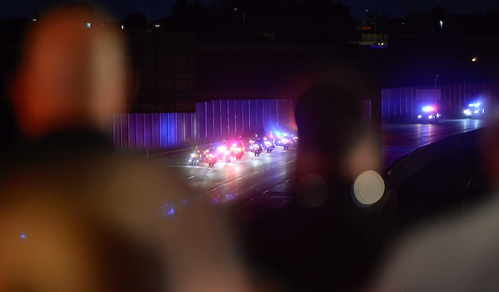 (Francisco Kjolseth  |  The Salt Lake Tribune)  The body of Utah firefighter Matt Burchett, 42, who died fighting a wildfire in California is honored by a firefighter detail along Murray Parkway as his body is returned home, traveling along I-215 after being flown in to the Utah Air National Guard in Salt Lake City on Wed. Aug. 15, 2018. The remains of the Draper battalion chief were transported to Jenkins-Soffe Mortuary in South Jordan.