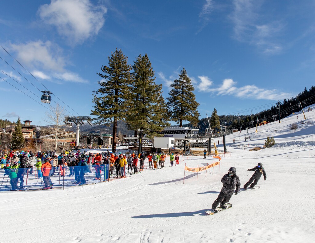 Skiers and snowboarders wait to board the Squaw One Express lift at Squaw Valley Ski Resort in Olympic Valley, Calif. on Dec. 12, 2020. Riders are reminded to remain six feet apart and only ride the lift with members of their household. (Cayce Clifford/The New York Times)