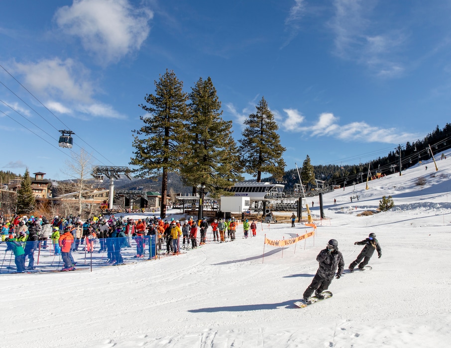 Skiers and snowboarders wait to board the Squaw One Express lift at Squaw Valley Ski Resort in Olympic Valley, Calif. on Dec. 12, 2020. Riders are reminded to remain six feet apart and only ride the lift with members of their household. (Cayce Clifford/The New York Times)