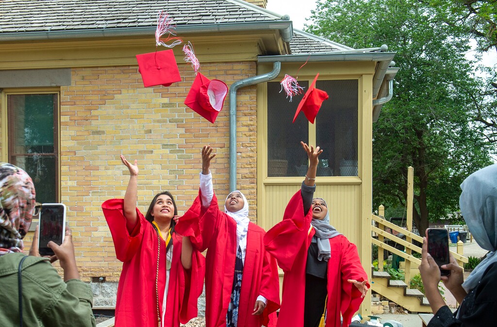 (Rick Egan  |  Tribune file photo)  Friends snap a graduation photo of Ames Academy graduates, Isabelle Raza ,Sara Ahmed, Sahra Madui, at Wheeler Farm, Friday, May 22, 2020.