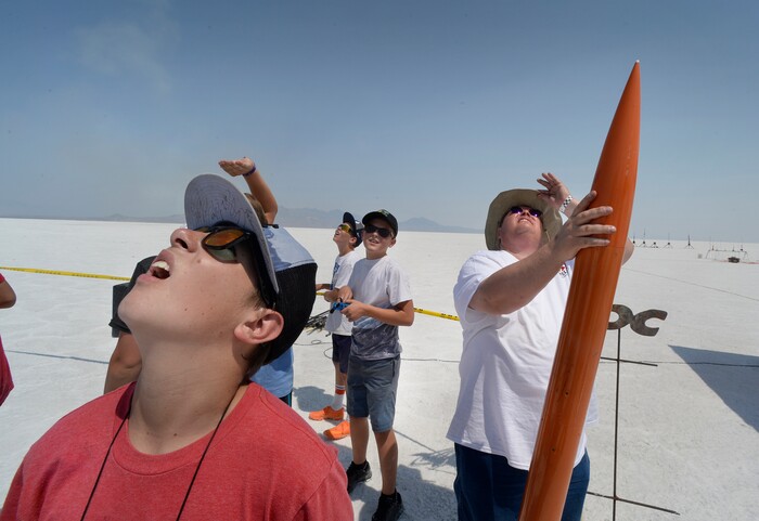 (Scott Sommerdorf   |  The Salt Lake Tribune)   Spectators crane their necks to follow the flight of a rocket launch on the Bonneville Salt Flats during "HellFire" — the event sponsored by the Utah Rocket Club on Saturday, Aug. 5, 2017.