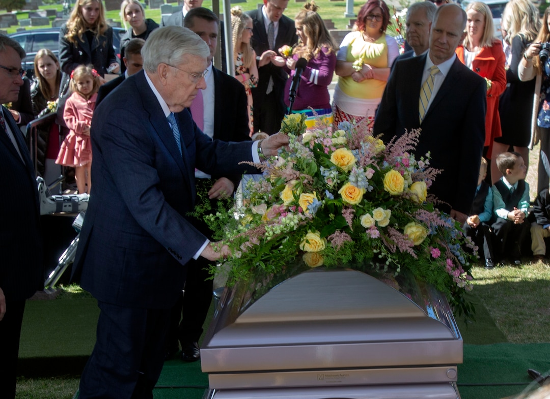 (The Church of Jesus Christ of Latter-day Saints)  M. Russell Ballard places a yellow rose in the casket of his wife, Barbara, who was laid to rest in the Salt Lake City Cemetery in 2018.