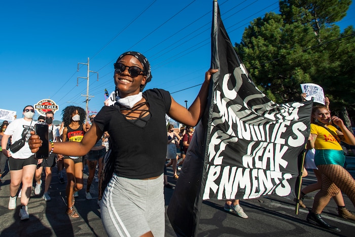 (Rick Egan  |  The Salt Lake Tribune)   Diane Bahati carries a banner as she dances in the streets of Salt Lake City, during the Dance Dance Revolution protest for racial equality, on Sunday, Aug. 9, 2020.