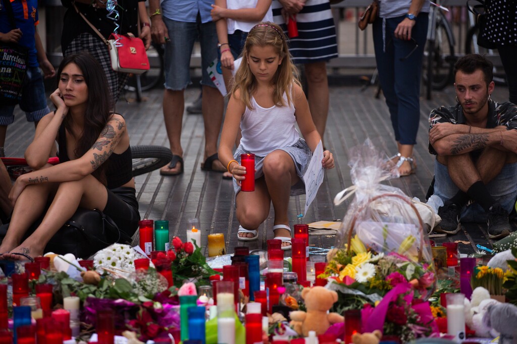 A girl places a candle after a terror attack that killed 14 people and wounded over 120 in Barcelona, Spain, Sunday, Aug. 20, 2017. (AP Photo/Emilio Morenatti)