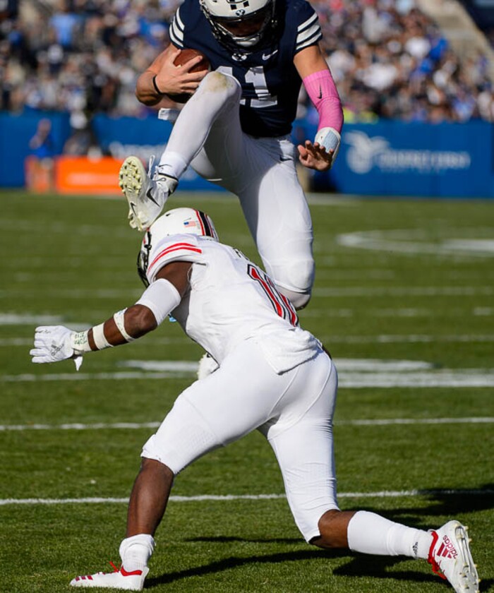 (Trent Nelson | The Salt Lake Tribune)  
Brigham Young Cougars quarterback Zach Wilson (11) leaps over Northern Illinois Huskies safety Trayshon Foster (11) as BYU hosts Northern Illinois, NCAA football in Provo, Saturday Oct. 27, 2018.