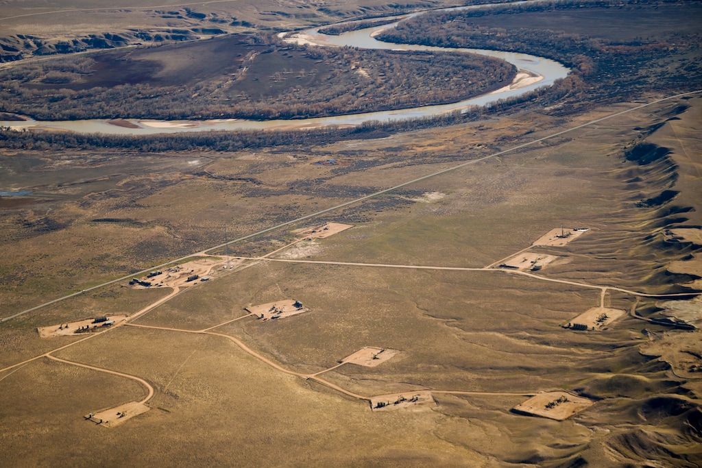 (Trent Nelson  |  The Salt Lake Tribune) An oil and gas field near the Ouray National Wildlife Refuge, pictured on Nov. 17, 2021. After a steady decline in production, drilling activity in the Uinta Basin is expect to rebound with rising energy prices. A new study by the University of Utah has found that 6 to 8% of the basin’s gas production escapes into the atmosphere. This photograph was taken on a flight provided by LightHawk.