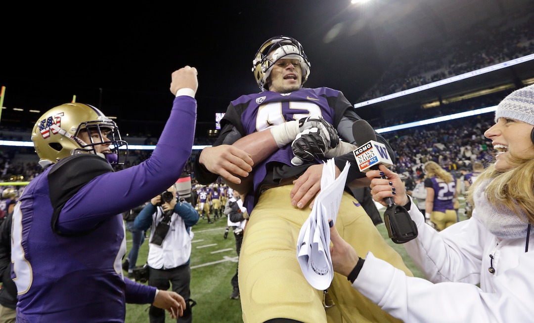 Washington kicker Tristan Vizcaino (43) is lifted in the air by a teammate as A.J. Carty, left, cheers while Vizcaino is being interviewed after kicking a field goal to end an NCAA college football game against Utah Saturday, Nov. 18, 2017, in Seattle. Washington won 33-30. (AP Photo/Elaine Thompson)