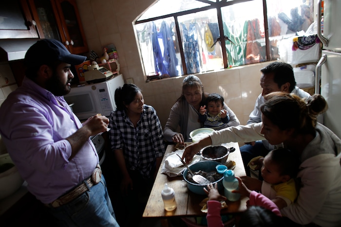 In this Aug. 23, 2017 photo, Juana Pedraza, center, holds her one-year-old grandson Jose Leonardo, who they call Leon, as the family eats breakfast in their home in Villa Cuauhtemoc, Mexico state. The gruesome death of Pedraza's 29-year-old daughter Jessica, Leo's mother, was part of a wave of killings of women plaguing the sprawling State of Mexico. From left are Jessica's former partner and Leo's father, Alejandro Garcia, Jessica's sister Zurisadai, father Abel, and sister Diana Laura with her two children. (AP Photo/Rebecca Blackwell)