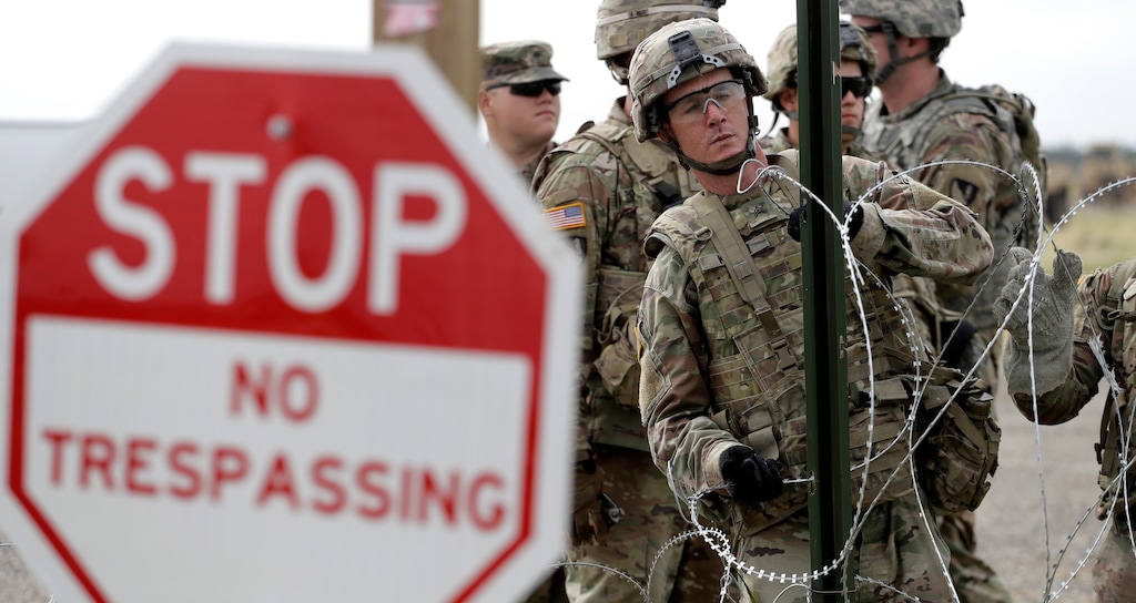 (Eric Gay | The Associated Press) Members of the U.S Army place razor wire for a temporary encampment for the troops near the U.S.-Mexico International bridge, Sunday, Nov. 4, 2018, in Donna, Texas.