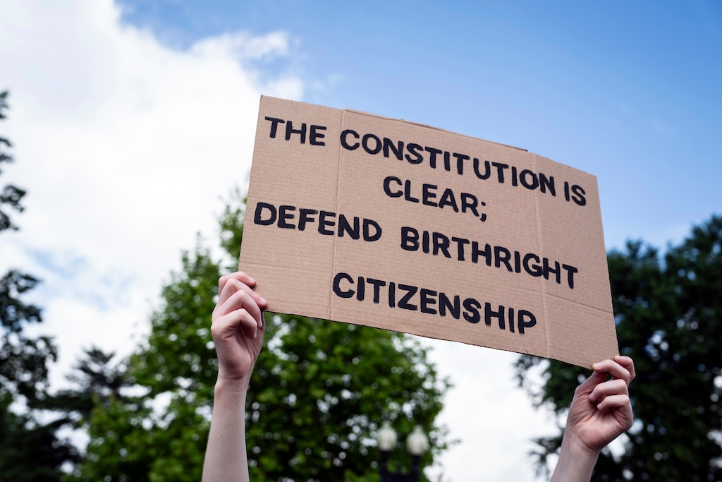 (Haiyun Jiang | The New York Times) A protester holds up a sign outside the Supreme Court in Washington on Wednesday morning, May 15, 2025.