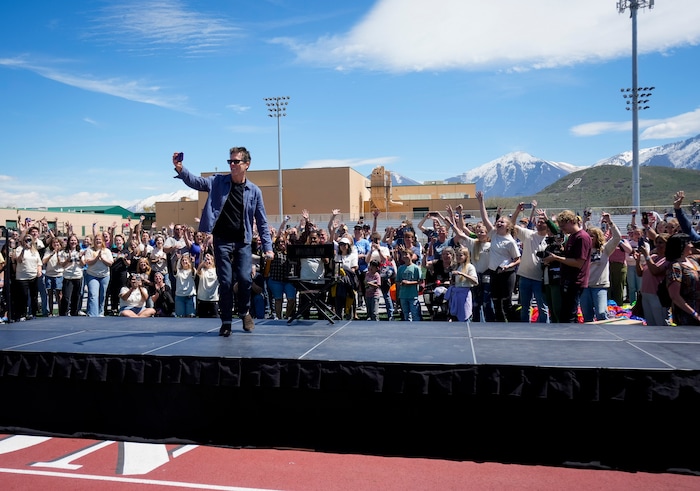 (Bethany Baker | The Salt Lake Tribune) Kevin Bacon records a video with the crowd, playing into the "six degrees from Kevin Bacon" game, following a charity event to commemorate the 40th anniversary of the movie "Footloose" on the football field of Payson High School in Payson on Saturday, April 20, 2024.