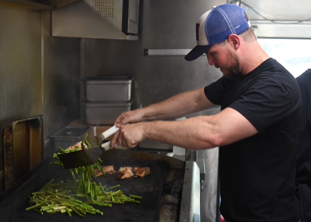 (Francisco Kjolseth  |  The Salt Lake Tribune)  Tristan Adler grills fresh asparagus inside the Clean Eats food truck.