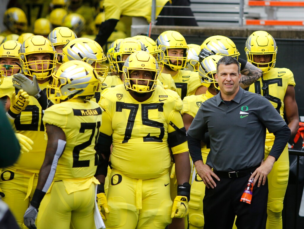 FILE - In this Nov. 23, 2018, file photo, Oregon coach Mario Cristobal stands with players before the team's NCAA college football game against Oregon State in Corvallis, Ore. The Ducks are the highest-ranked Pac-12 team and the North Division favorite. They go into Saturday night’s game against Auburn, the opener of Cristobal’s second season, with a three-game winning streak after a 9-4 season. (AP Photo/Timothy J. Gonzalez, File)
