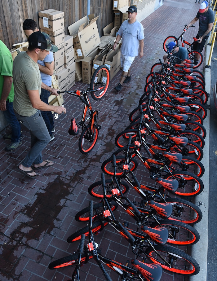 (Francisco Kjolseth  |  The Salt Lake Tribune)  Volunteers and workers at Squatter's Pub Brewery assemble 80 bicycles on Tuesday, May 29, 2018, at the brewery which will be given away to 1st and 2nd graders at Washington Elementary on Wednesday. Part of the program is backed by the Can'd Aid Foundation.