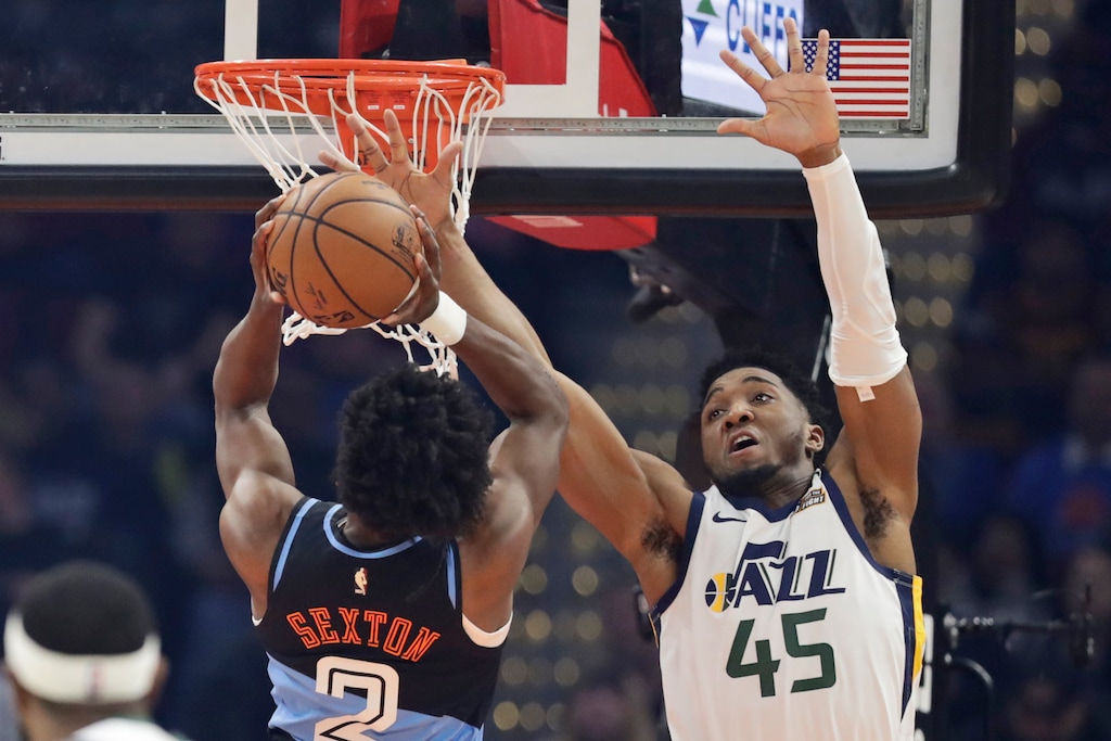 Utah Jazz's Donovan Mitchell (45) blocks a shot by Cleveland Cavaliers' Collin Sexton (2) in the first half of an NBA basketball game, Monday, March 2, 2020, in Cleveland. (AP Photo/Tony Dejak)