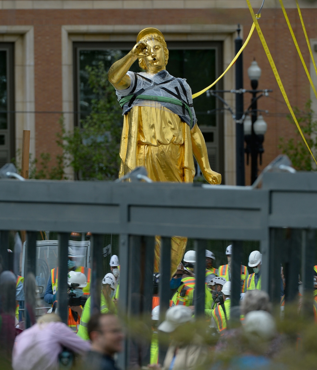 (Francisco Kjolseth  |  The Salt Lake Tribune) People gather to get a closer look of the Angel Moroni statue after it was pulled from atop the Salt Lake Temple of The Church of Jesus Christ of Latter-day Saints on Monday, May 18, 2020. The temple closed in December for seismic upgrades and sustained minor damager during the March 18, 2020, magnitude 5.7 earthquake when the trumpet held by the angel fell off and several smaller spire stones were displaced.