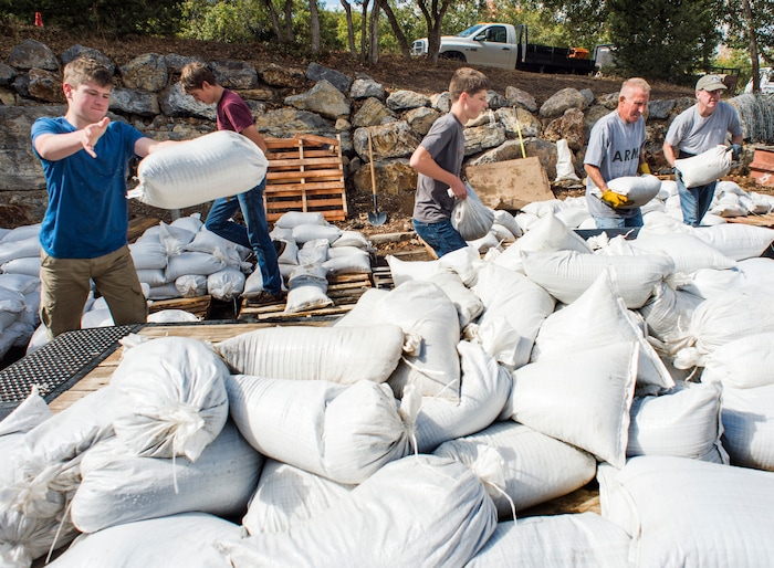 (Rick Egan  |  The Salt Lake Tribune)     Residents of Woodland Hills, make sand bag barricades, after being warned of possible flash floods with the coming rain, due to the recent fires in the area.  Monday, Oct. 1, 2018.


