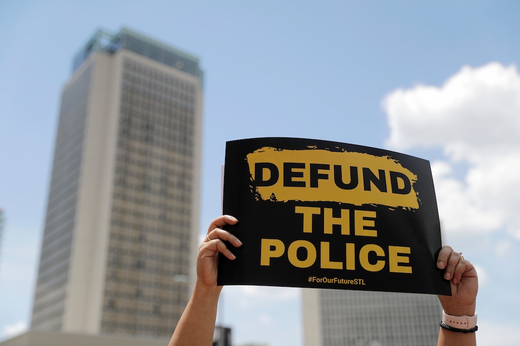 (Jeff Roberson | AP photo)
A person holds up a sign advocating for defunding the police as people gather to mark Juneteenth, Friday, June 19, 2020, in St. Louis. Juneteenth is the holiday celebrating the day in 1865 that enslaved black people in Galveston, Texas, learned they had been freed, more than two years after the Emancipation Proclamation was signed.